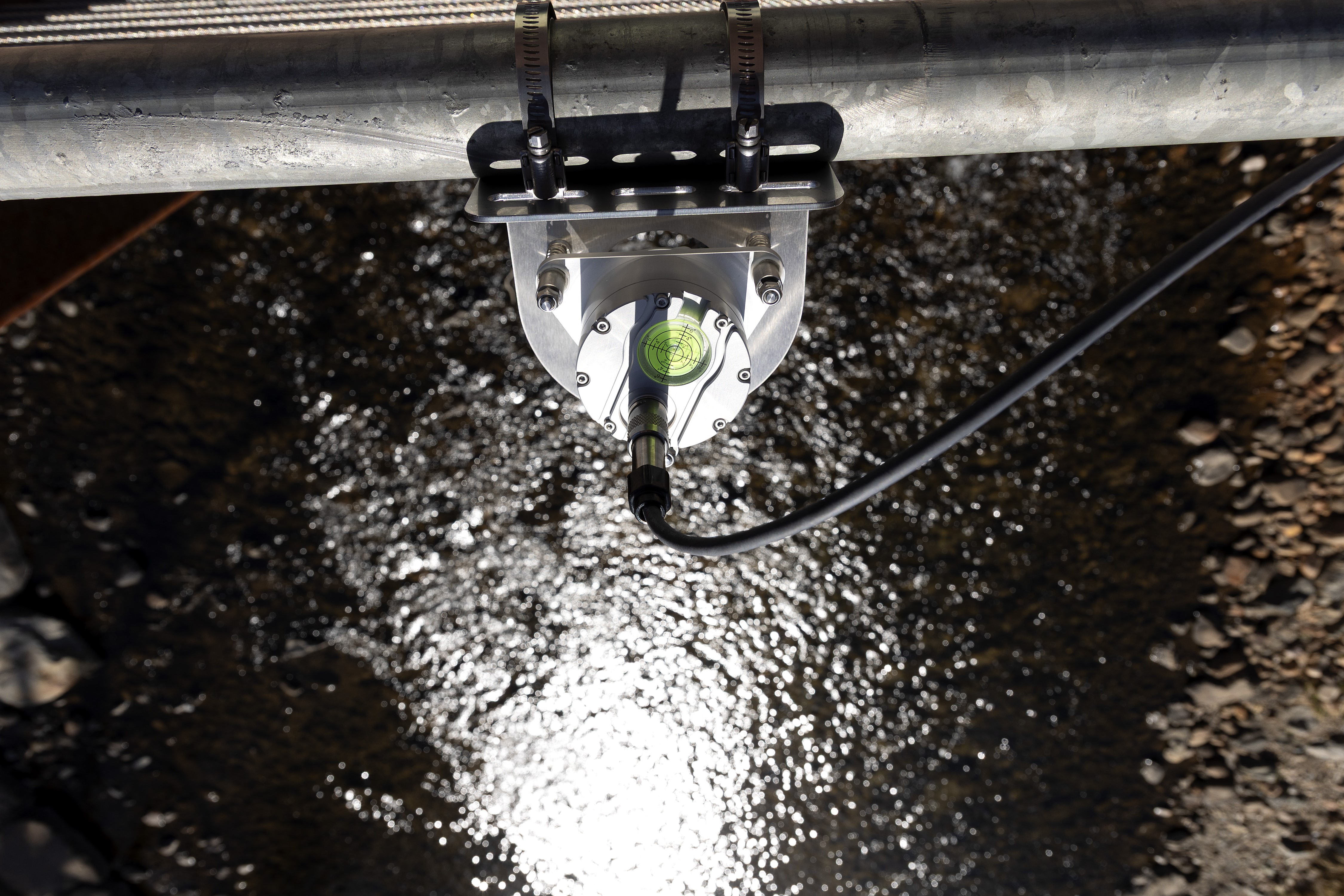 A river photo taken from above looking down on a water measuring device.