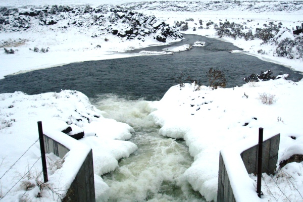A river in the winter that is partially frozen.