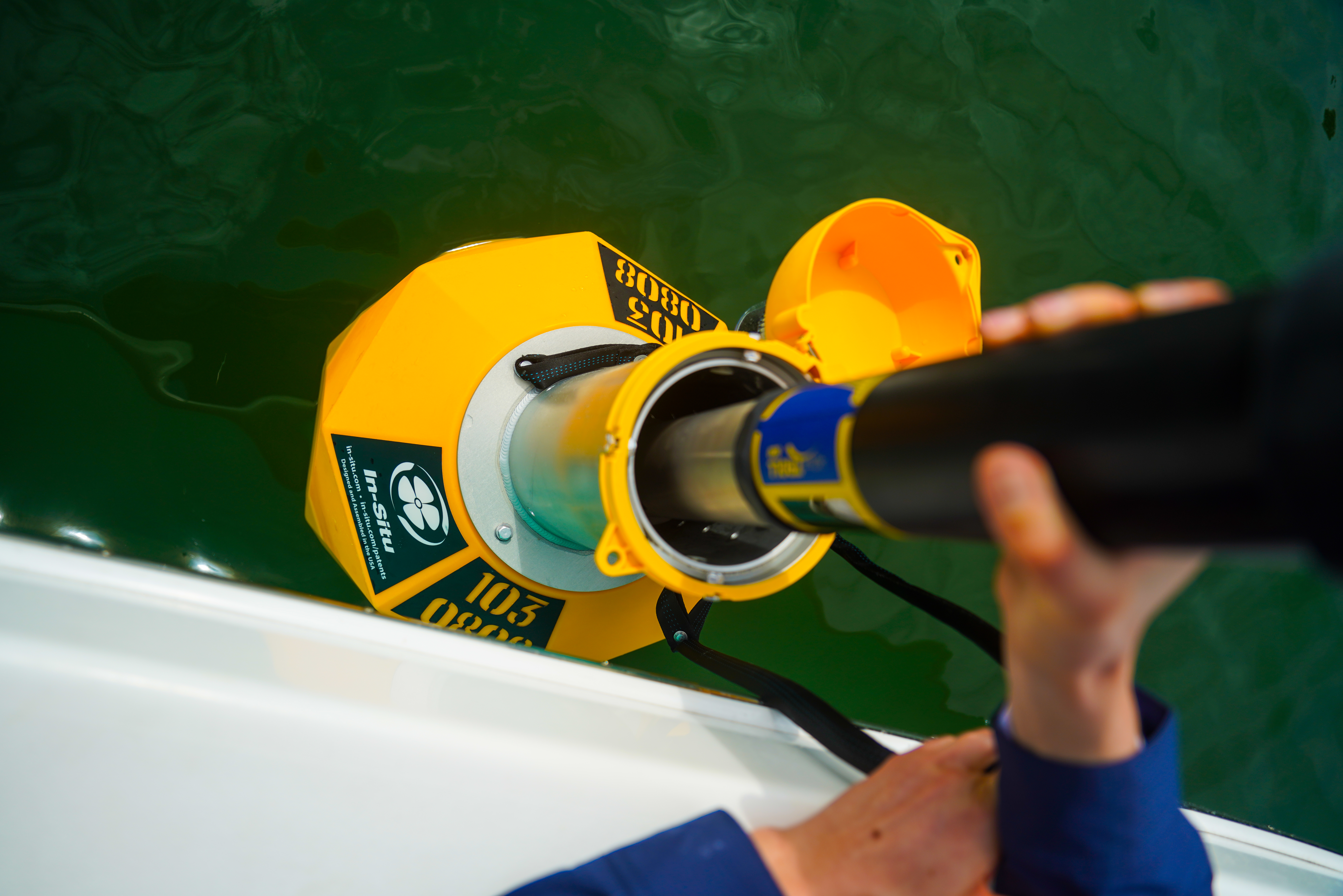 A person putting a blue device inside of a yellow buoy